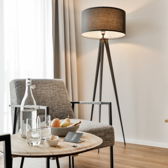 Sitzecke mit Stehlampe in einem Superior Zimmer. Im Vordergrund ein kleiner Beistelltisch.