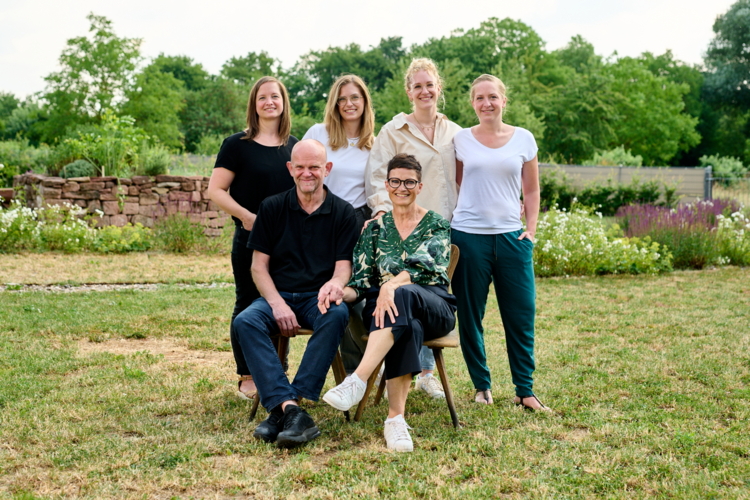 Die sechs Familienmitglieder sind für ein Familienfoto im Garten zusammengekommen.