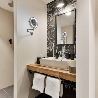 Waschbecken mit Accessoires in einem Bad der Superior Zimmer.