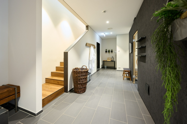 Zu sehen ist der Wellnessbereich. Links die Treppe, die zum Ruheraum geht. Rechts die Tür zur Sauna.